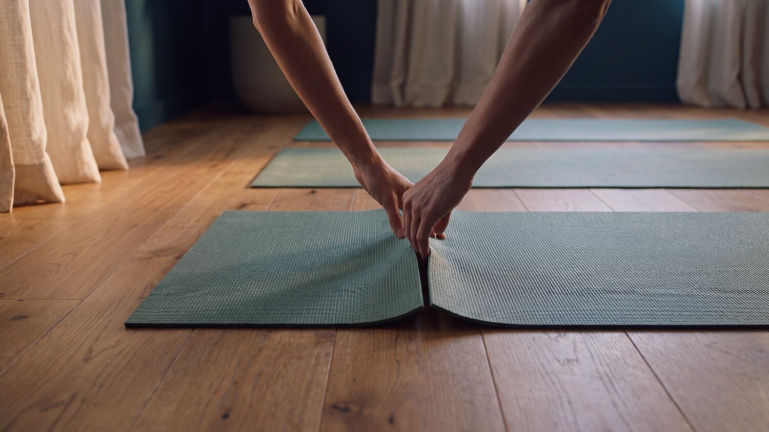 Pessoa prepara um tapete para praticar exercícios em casa